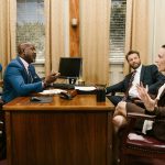 Three attorneys in a legal discussion at a well-appointed law office.